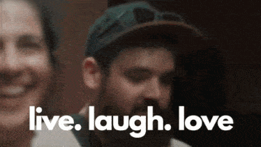 a man with a beard is laughing with the words live laugh love behind him