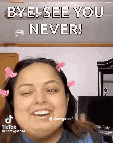 a woman with pink hair clips in her hair is smiling and says bye see you never
