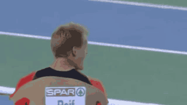 a man is sitting in a chair on a track with a sign that says spar on it .