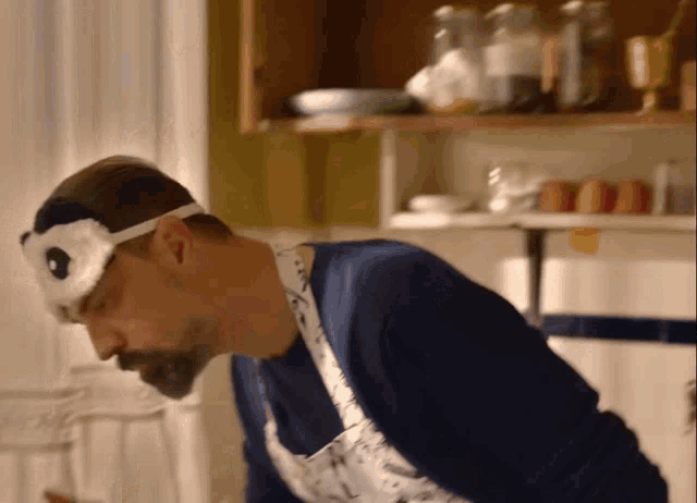 a man wearing a mask and an apron is cooking