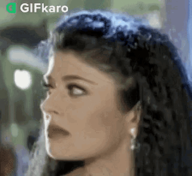 a close up of a woman 's face with a shocked look on her face .