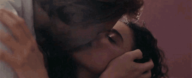 a man is kissing a woman on the forehead