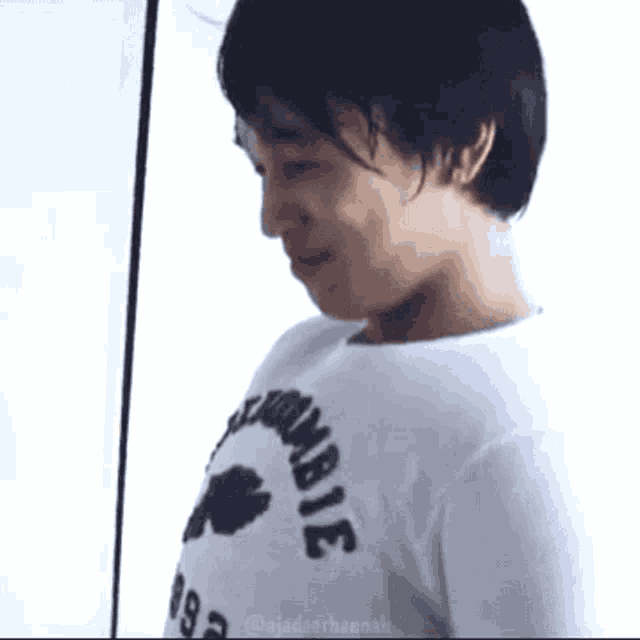a man wearing a white t-shirt that says zombie on it