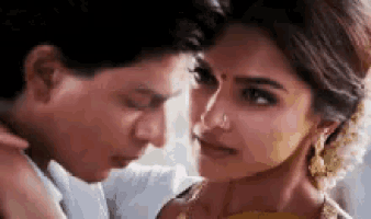 a man and a woman are looking at each other and kissing .