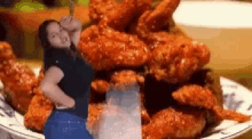 a woman stands in front of a plate of fried chicken