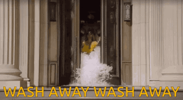 a woman in a yellow shirt is being splashed with water and the words wash away wash away