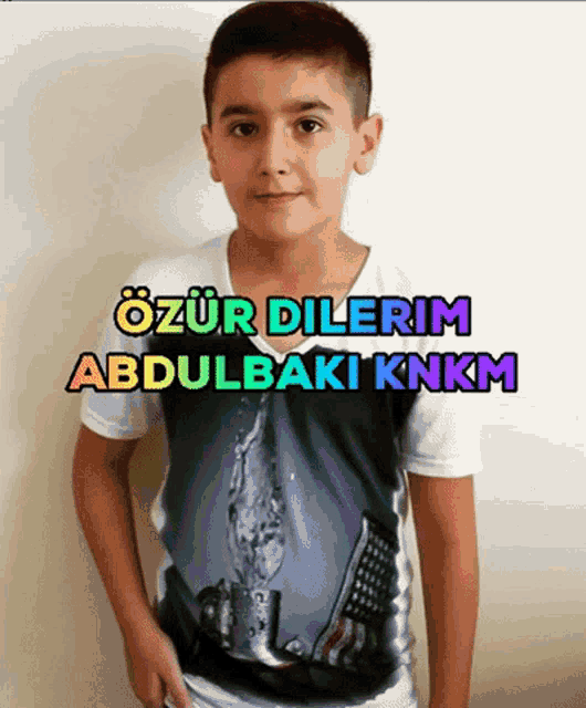 a boy wearing a t-shirt that says abdulbaki knkm on it