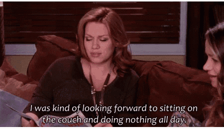 a woman is sitting on a couch looking forward to sitting on the couch and doing nothing all day