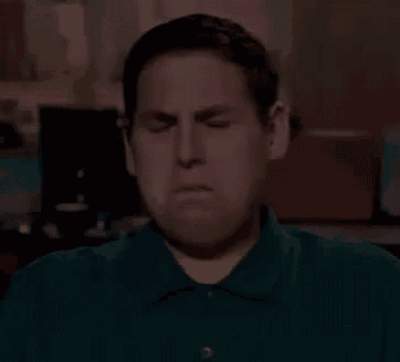 a man is making a funny face with his eyes closed .