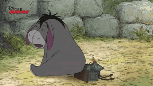 eeyore from winnie the pooh sits in the dirt next to a small house