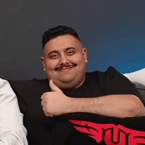 a man with a mustache is giving a thumbs up sign .