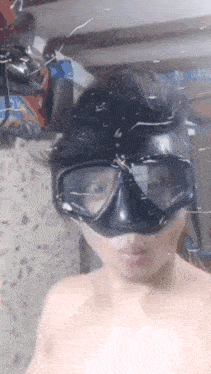 a man without a shirt is wearing a diving mask and goggles