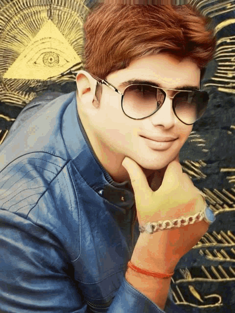 a man wearing sunglasses and a bracelet has his hand under his chin