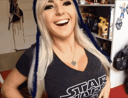 a woman wearing a black star wars shirt is smiling