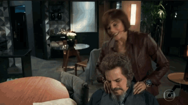 a woman is putting her hand on a man 's head
