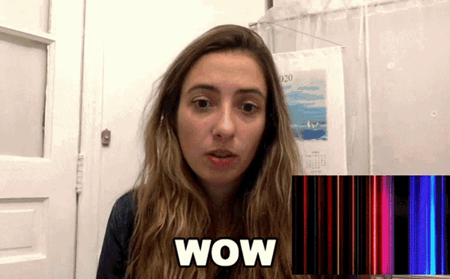 a woman says wow in front of a calendar with the year 2020 on it