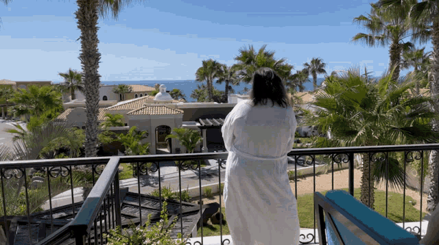a woman in a bathrobe looks out over the ocean