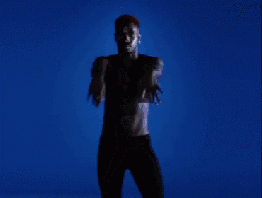 a man in a red crop top and red shorts is dancing
