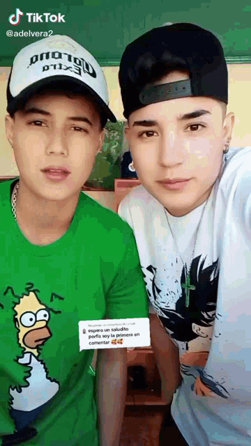 two young men posing for a picture with one wearing a homer simpson t-shirt