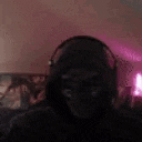 a person wearing headphones is standing in a room with a pink light in the background .