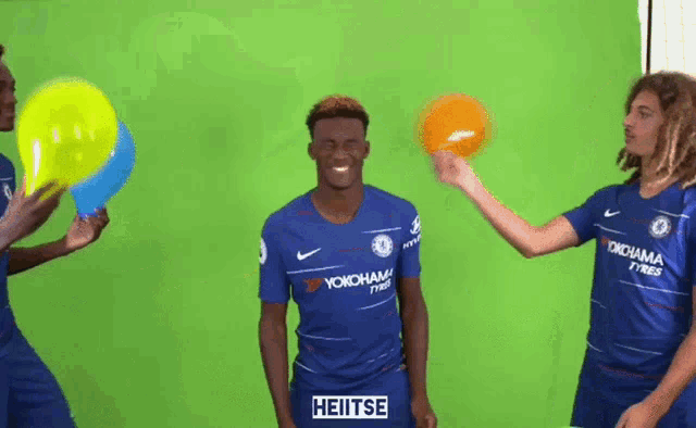 a group of soccer players are playing with balloons and one of them has heitse written on his jersey