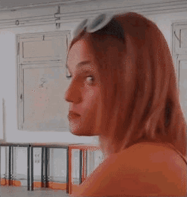 a woman wearing sunglasses looks to the side in a room