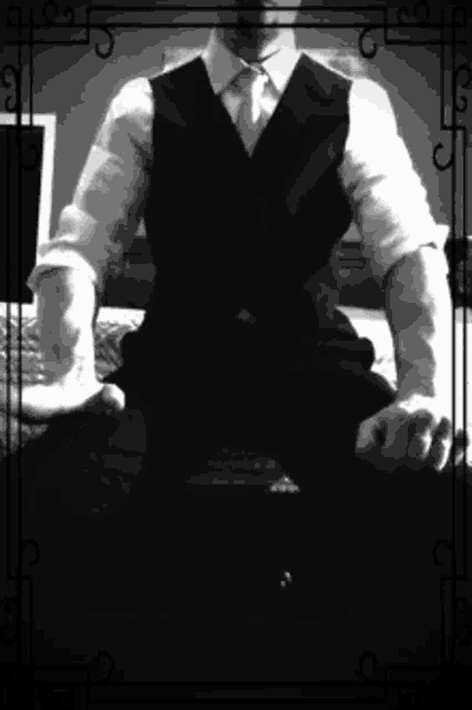 a man in a suit and tie is sitting in front of a laptop computer
