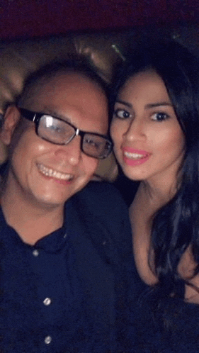 a man and a woman are posing for a picture together .
