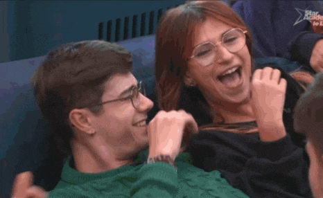 a man and a woman are laughing together in a room