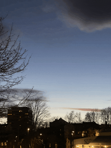 a blue sky with a few clouds and a few buildings in the foreground