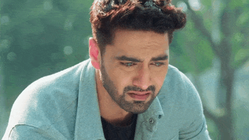 a man with a beard is crying and looking down