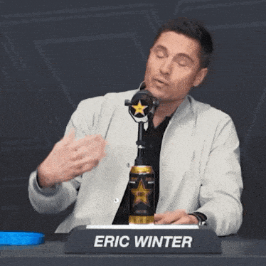 eric winter sits at a desk with a can of rockstar energy drink in front of him