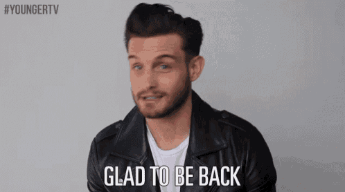 a man in a leather jacket is smiling and says glad to be back .