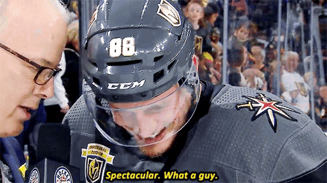 a hockey player with the number 88 on his helmet talks to a man