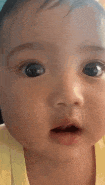 a close up of a baby 's face with its mouth open .