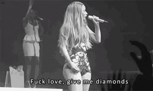a black and white photo of a woman singing into a microphone with the words `` fuck love , give me diamonds '' below her .