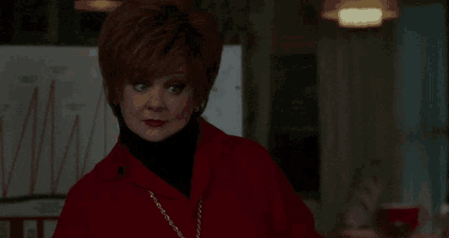 a woman in a red jacket is looking at something
