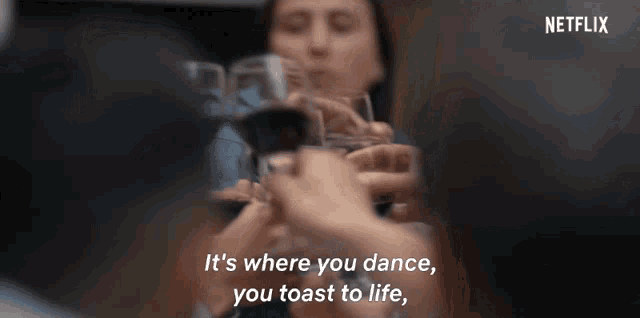 a group of people are toasting with wine glasses and the words " it 's where you dance you toast to life " are visible