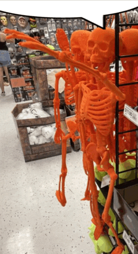 a display of orange skeletons in a store with a price tag of $ 27.95