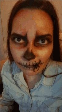 a woman with a spider on her face has stitches in her mouth