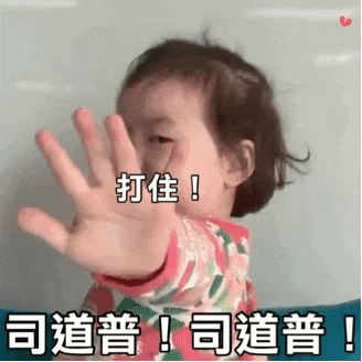 a little girl is making a stop sign with her hand in a foreign language .