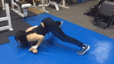 a woman is doing push ups in a gym