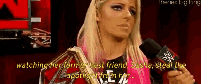 a female wrestler is talking into a microphone while wearing a wrestling belt .