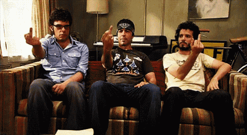 three men are sitting on a couch and one is wearing a t-shirt that says space