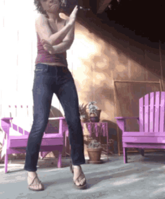 a woman standing in front of purple chairs on a patio