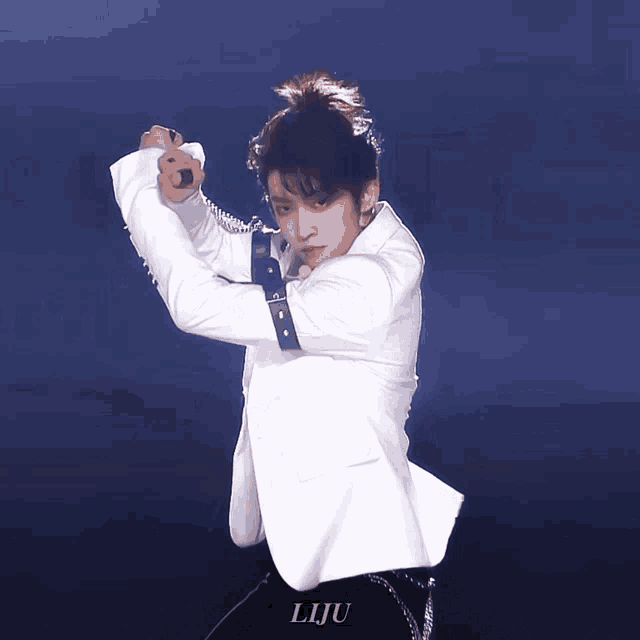 a man in a white jacket and black pants has liju written on the bottom of his pants