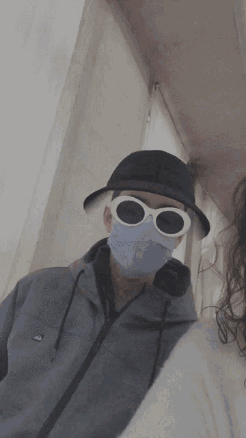 a man wearing a mask and white sunglasses