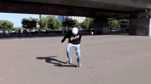 a person riding a skateboard wearing a sweatshirt that says " yklon " on it