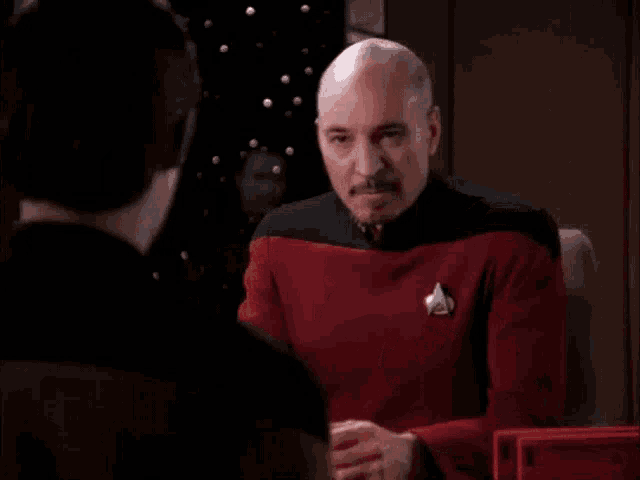 a man in a red shirt is blowing his nose