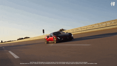 a red car is driving down a road with the alfa romeo logo on the bottom
